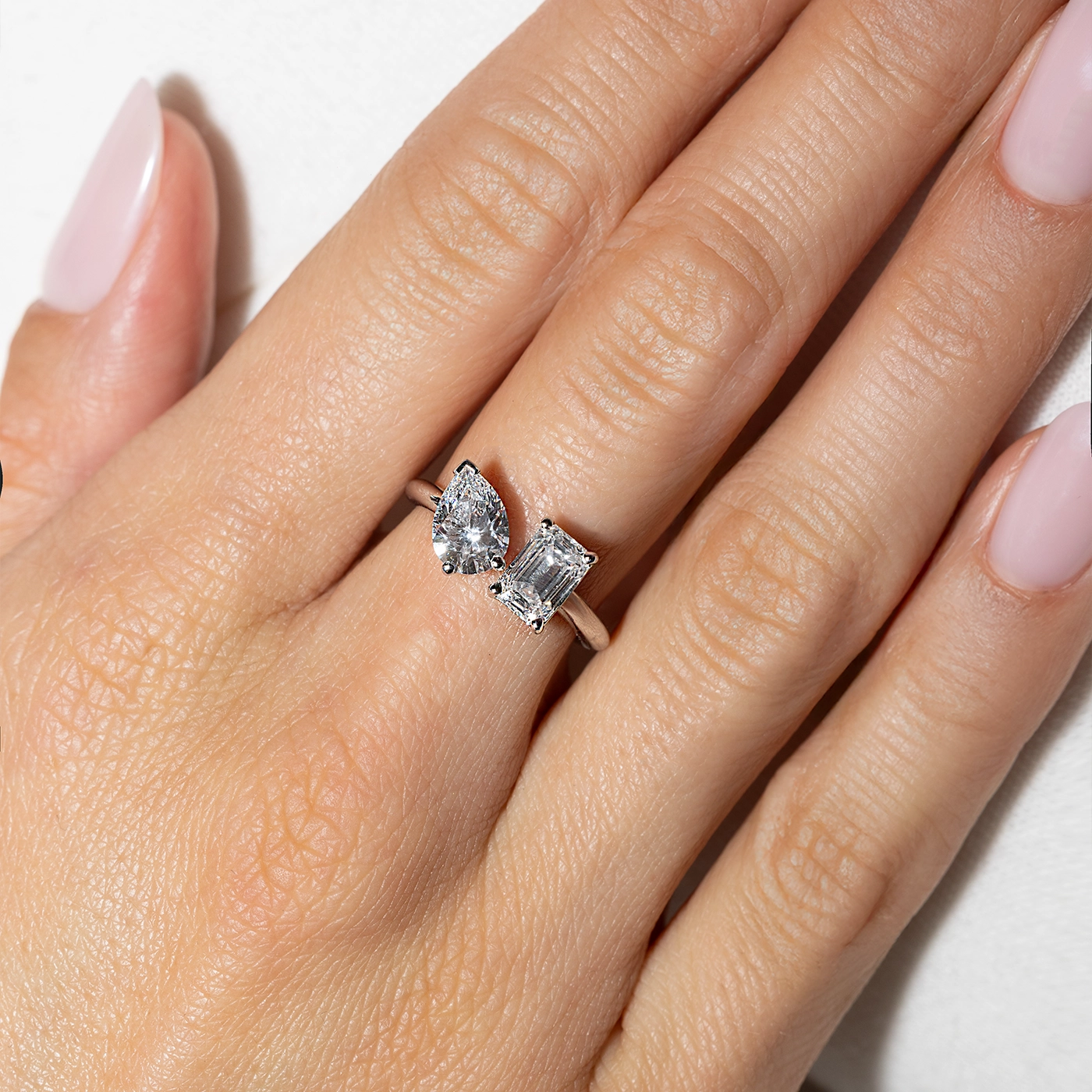 Toi Moi lab diamond ring with pear and emerald-cut stones in white gold worn on finger