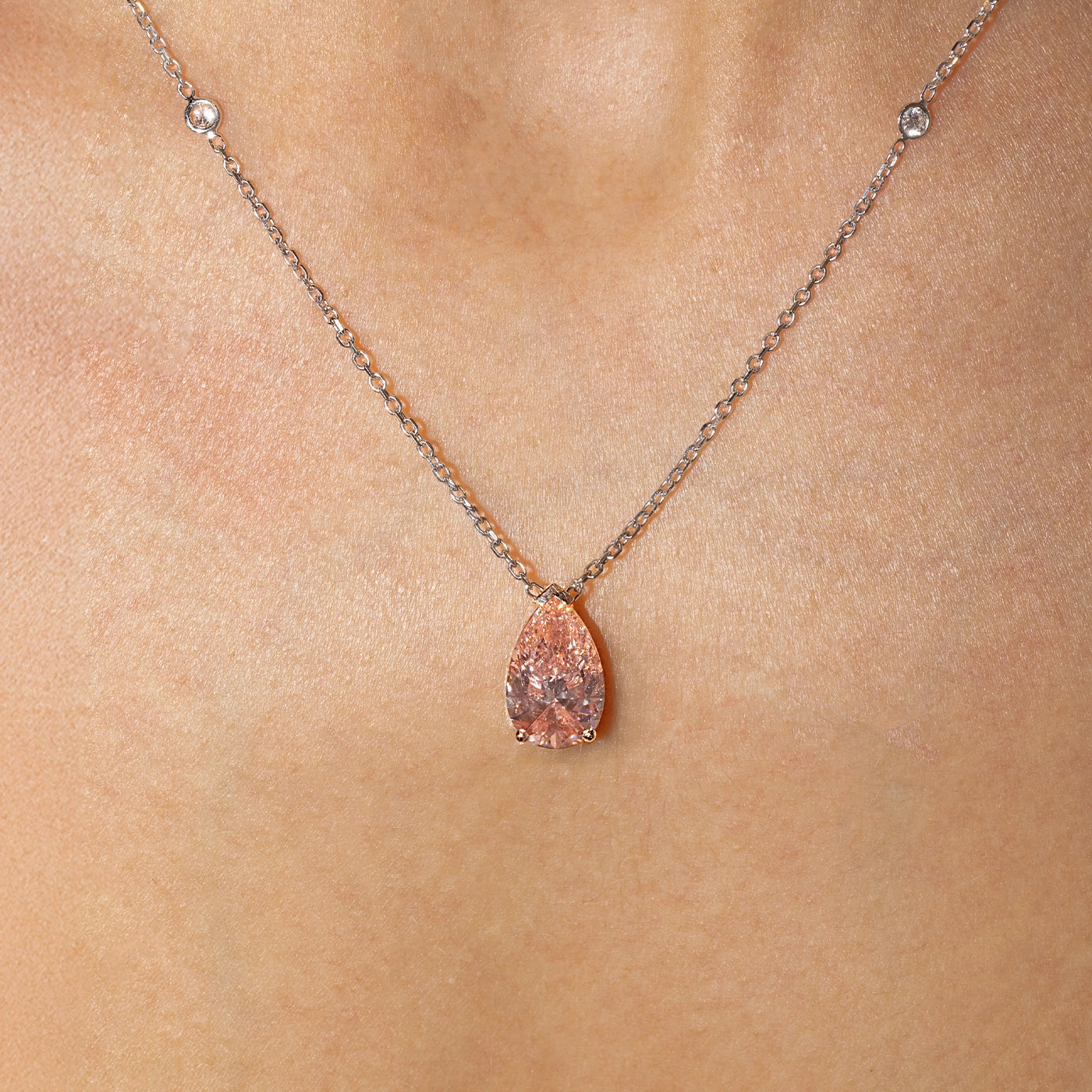 Pear-shaped pink lab-grown diamond pendant necklace in rose gold with sautoir, worn on the neck.