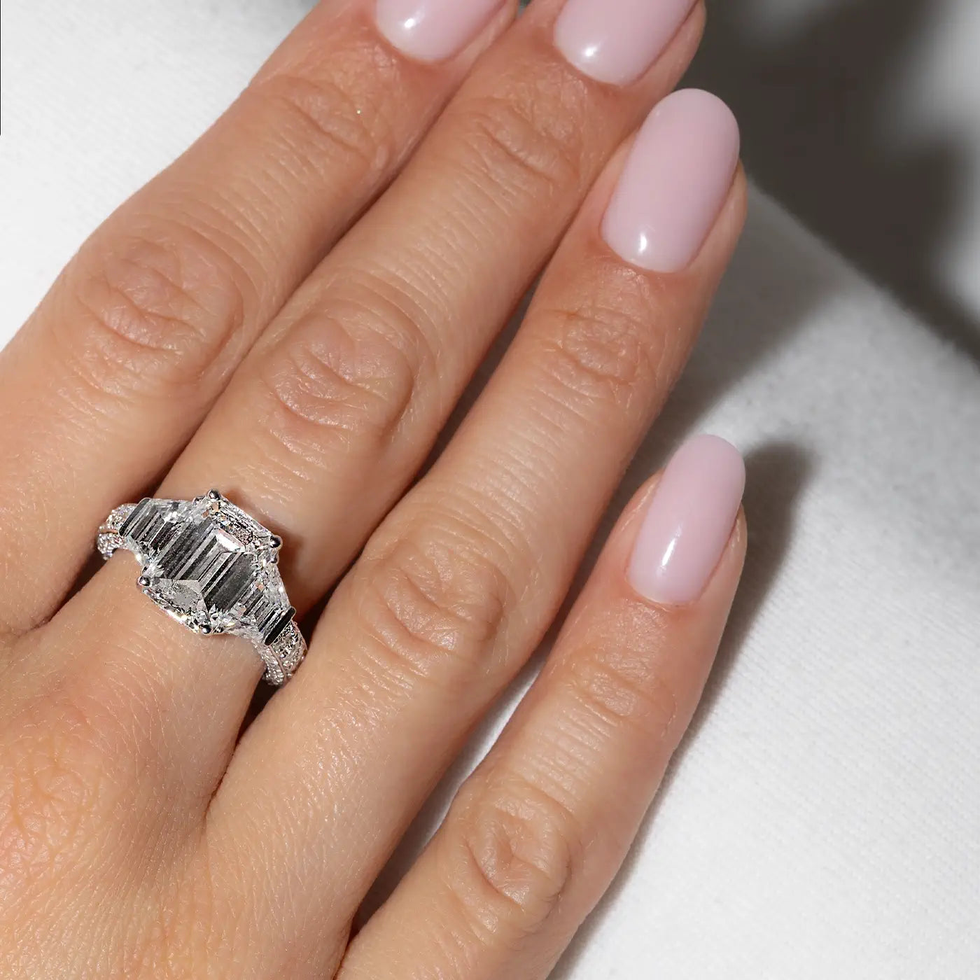 Emerald-shaped Lab diamonds Trapeze Trilogy in 18k white gold worn on hand by the model