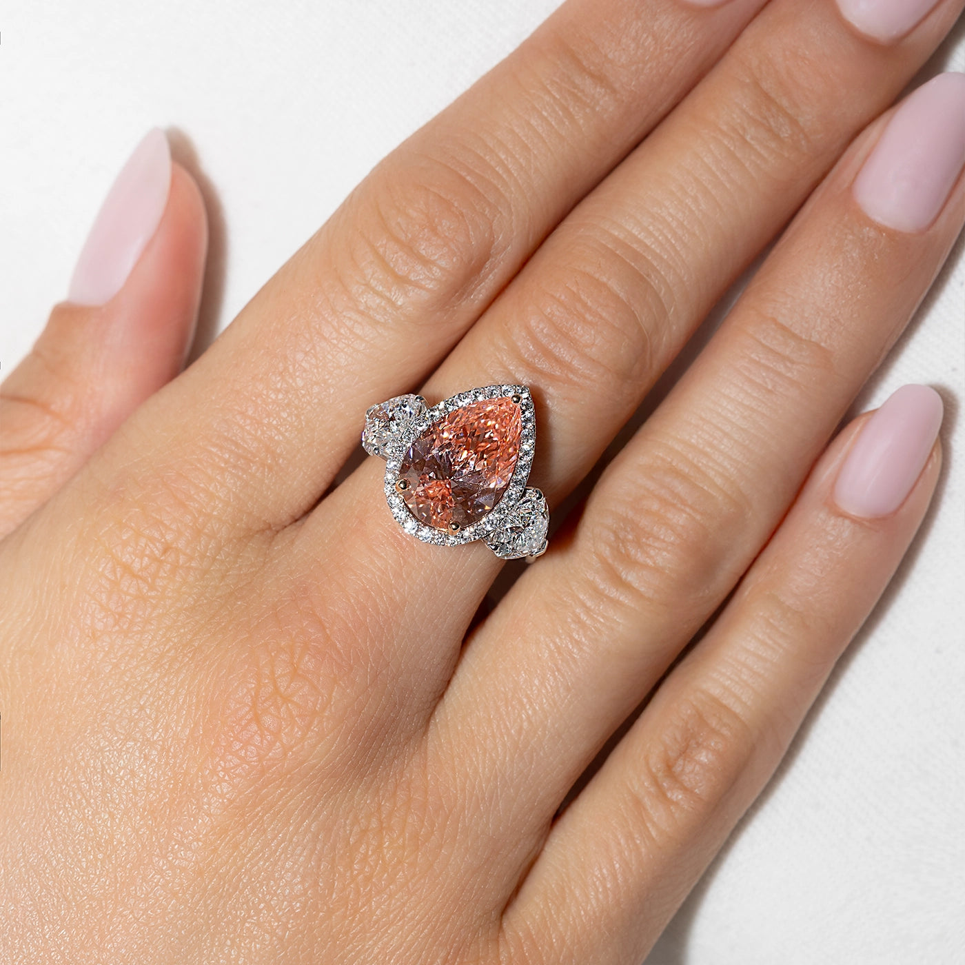 Pear-shaped fancy pink lab-grown diamond halo ring in white gold with heart side stones