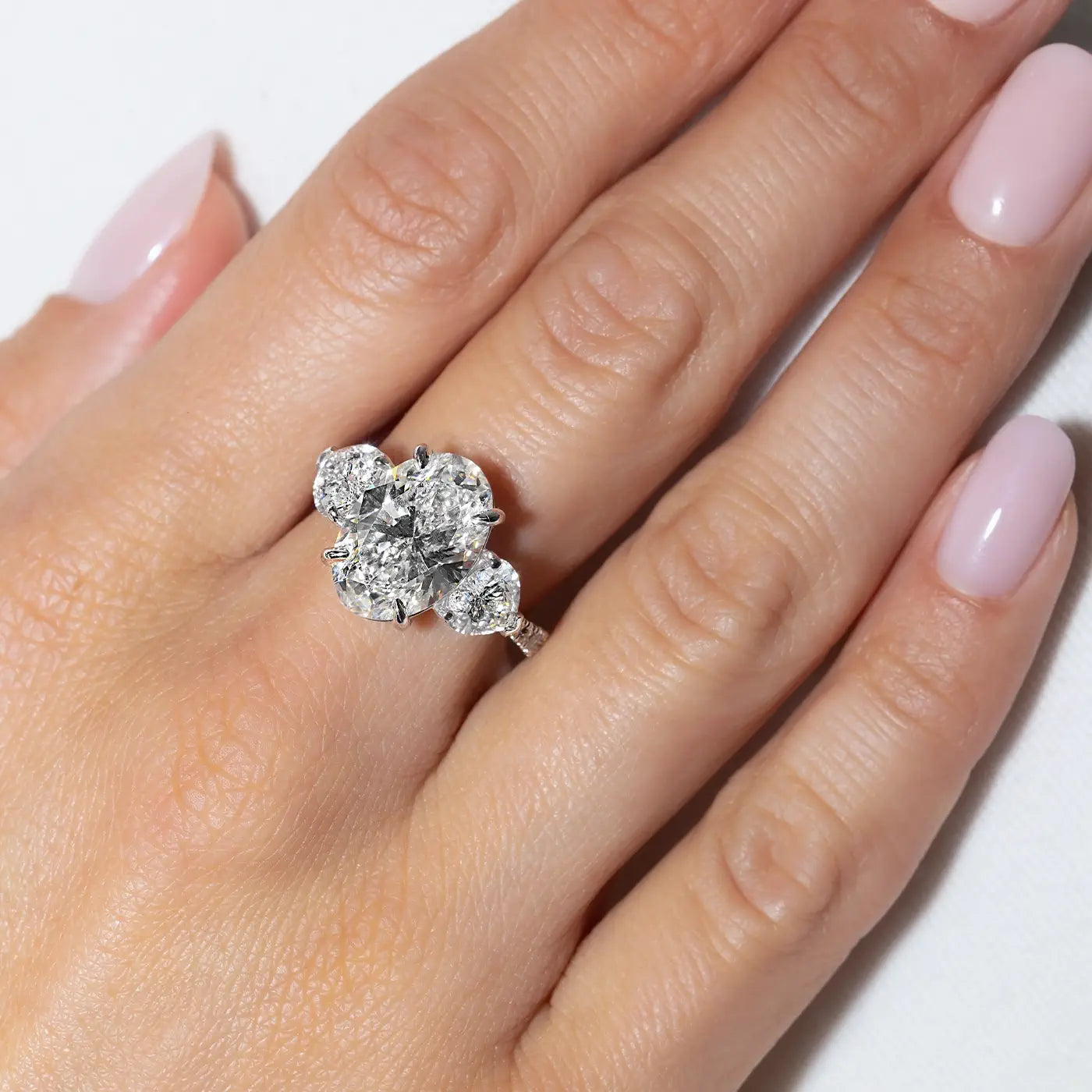 Oval-shaped lab diamonds in heart trilogy, settings made in 18k white gold worn on hand