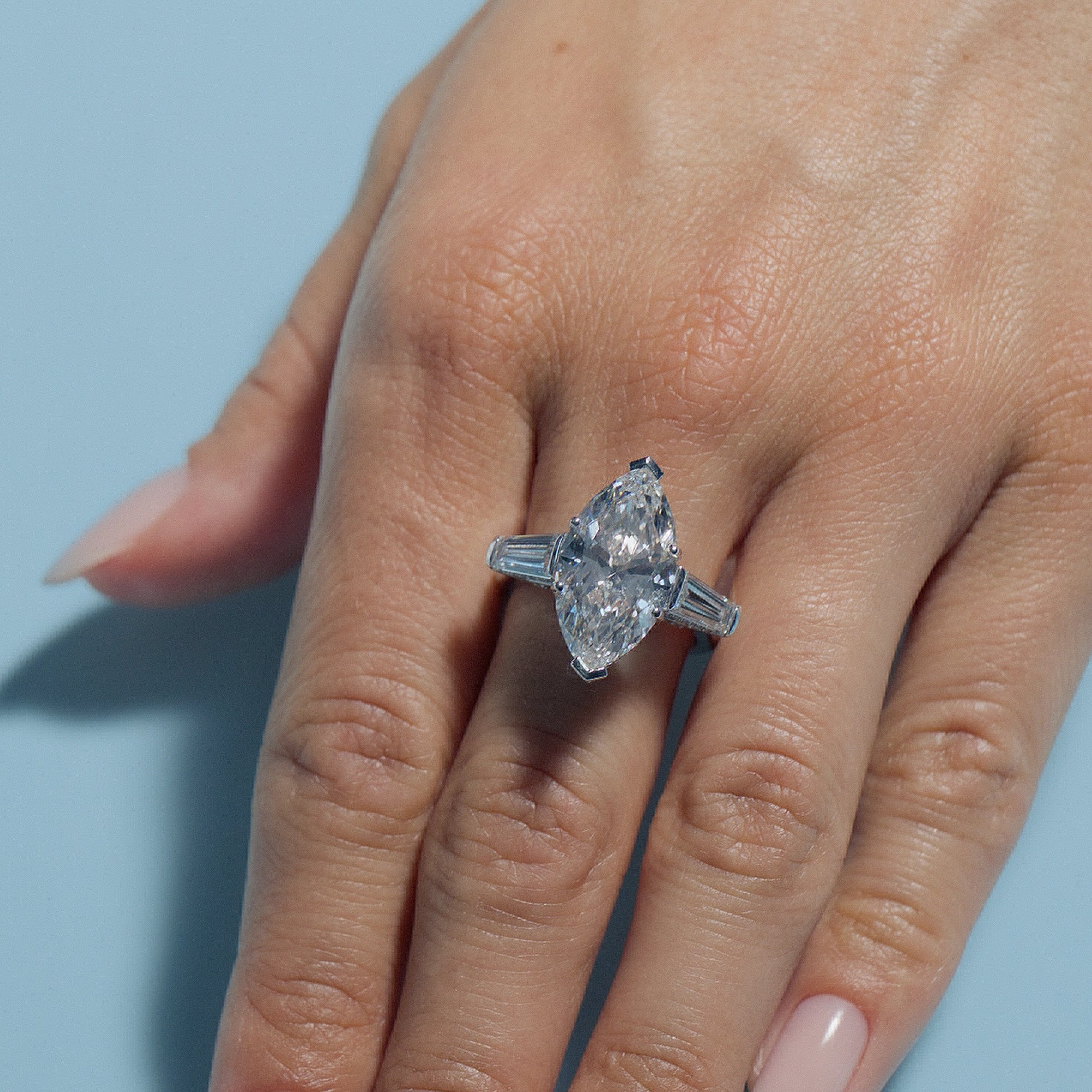 6.53ct Marquise Lab Diamond Intricate Trilogy ring on a hand against a light blue background