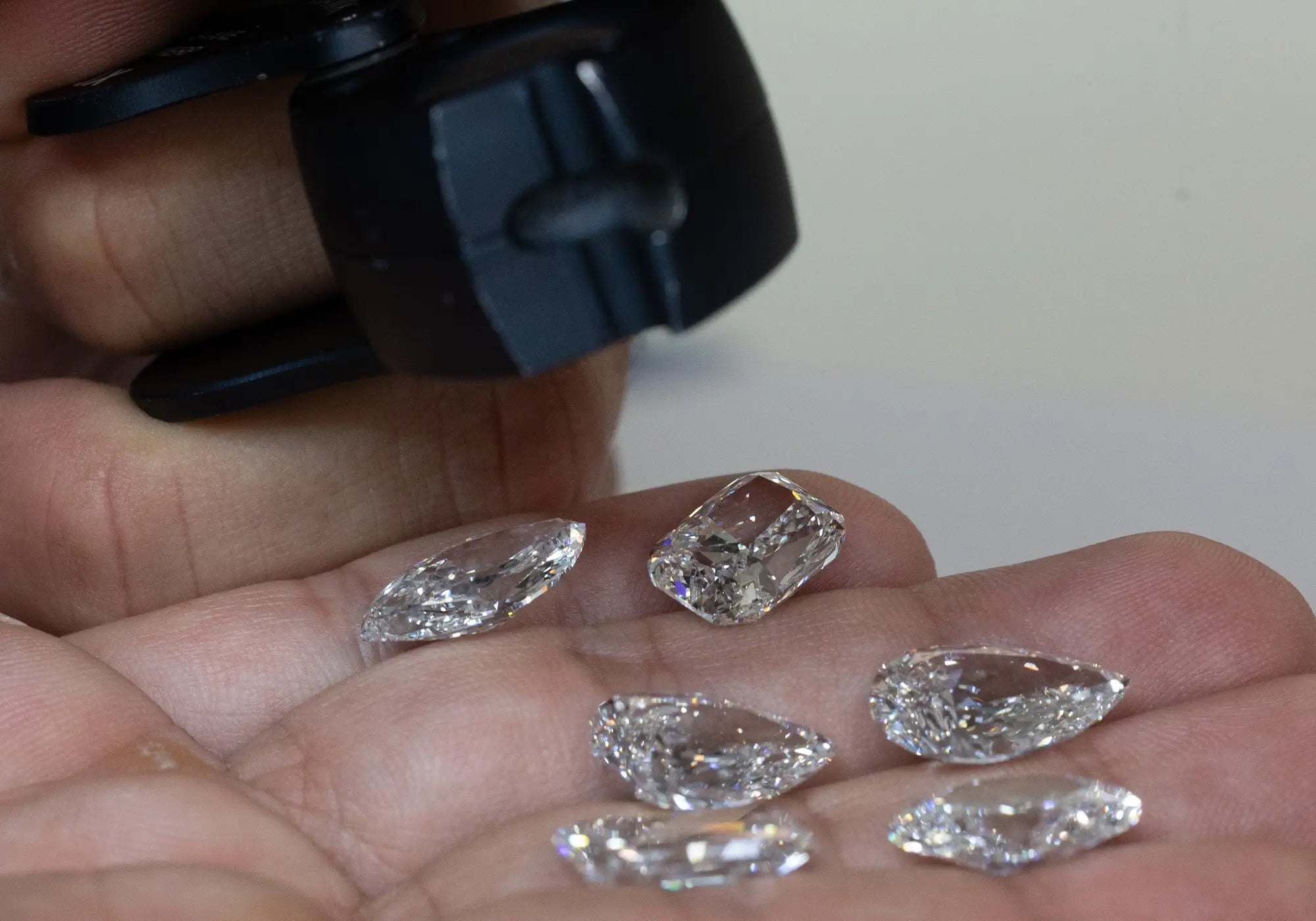 Jeweler inspecting the clarity of different shapes of lab-grown diamonds