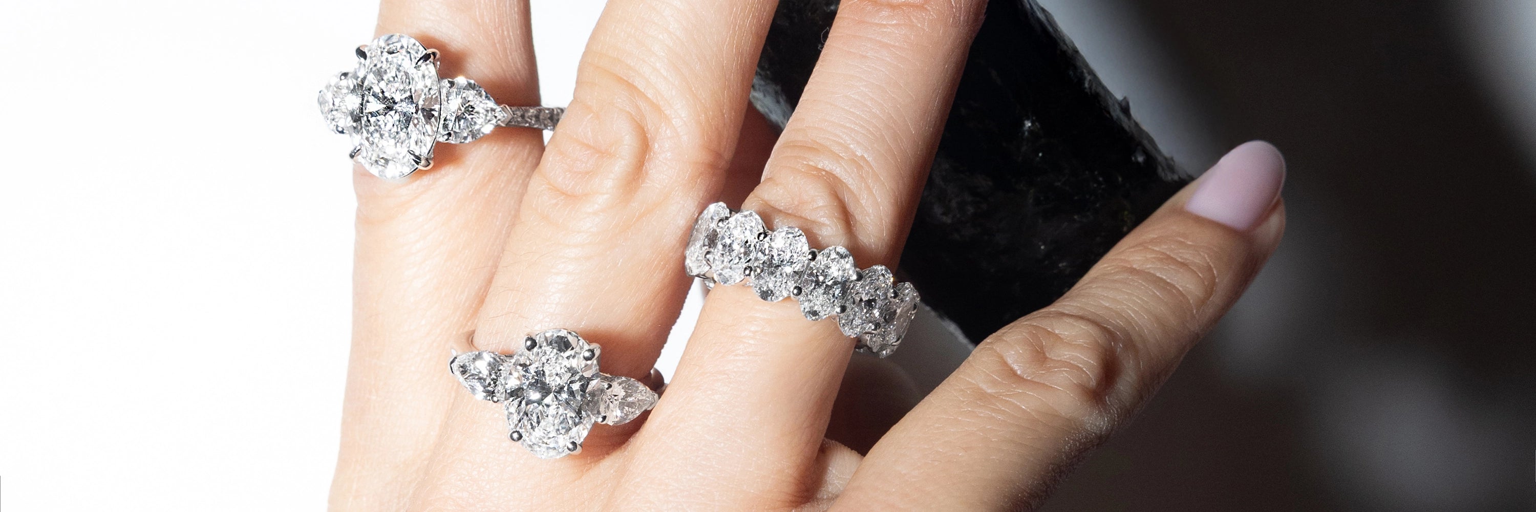 Model wearing diamond rings with round brilliant stones in white gold, luxury fine jewelry