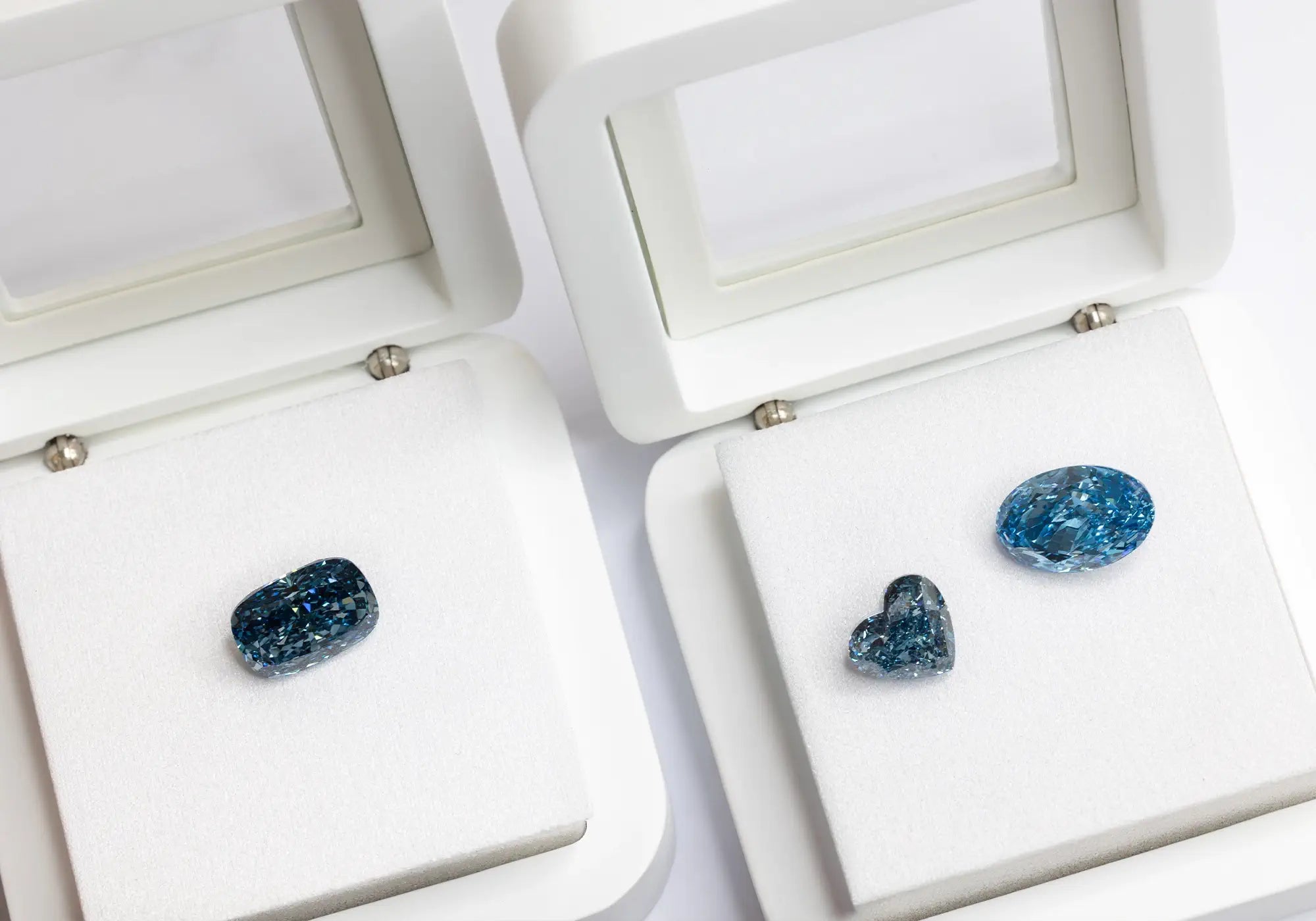 Three Fancy Blue Loose Lab Grown Diamonds on a white stone box