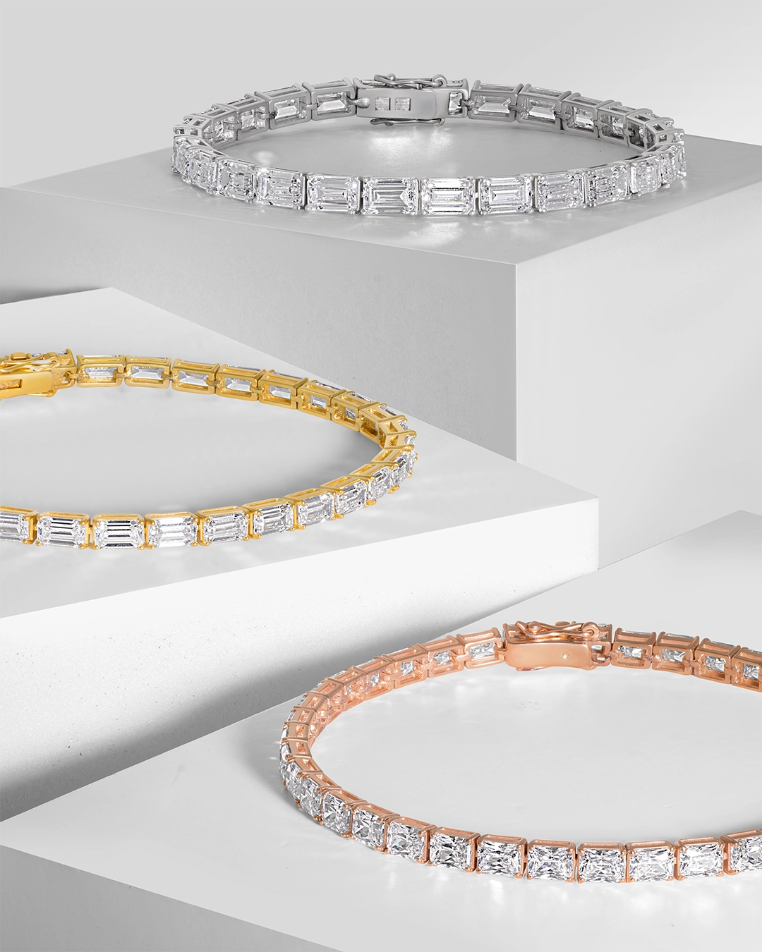 Luxury emerald-cut diamond tennis bracelets in white, yellow, and rose gold settings