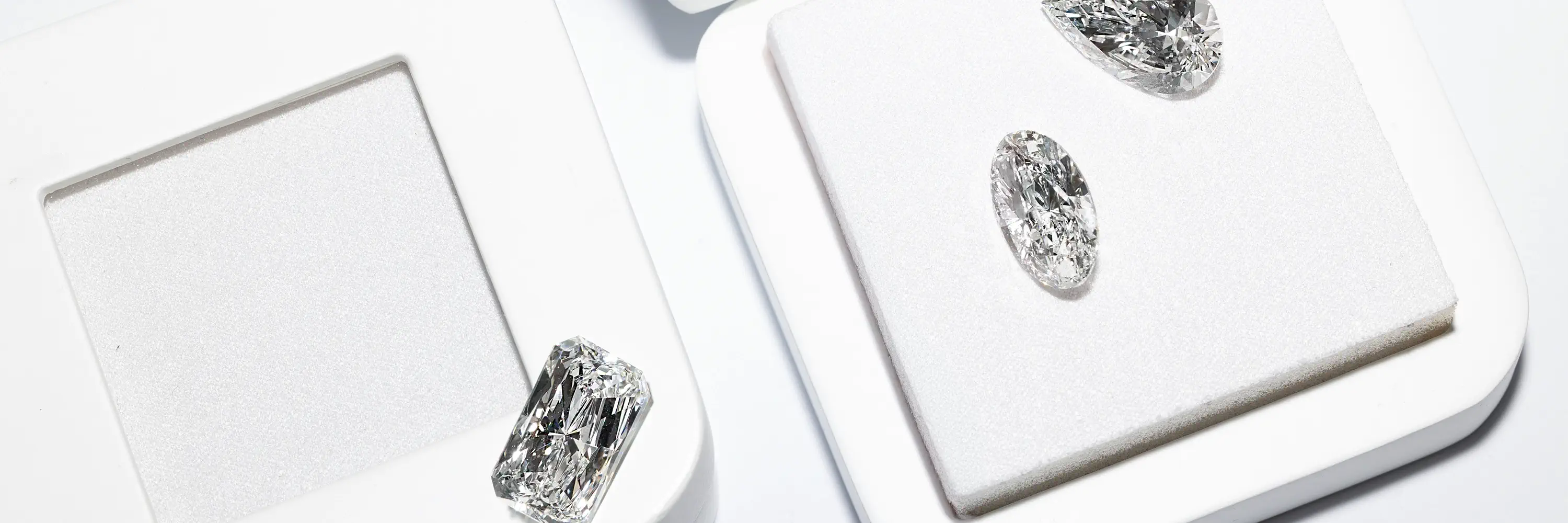 2 pear shape, 1 cushion, 1 oval loose lab-grown diamonds with tweezer on the side.