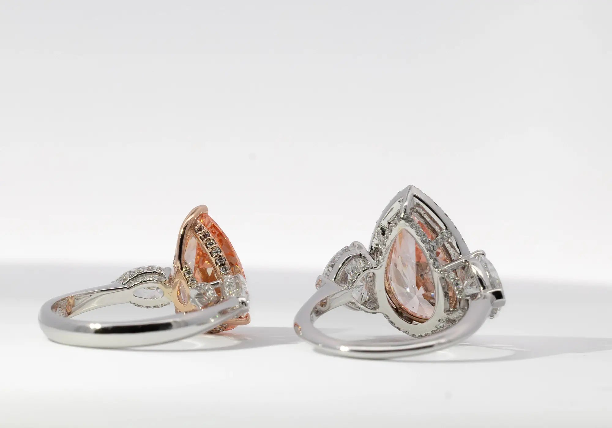 Two pear-shaped rings side by side, highlighting the detailed settings and mixed metal look.