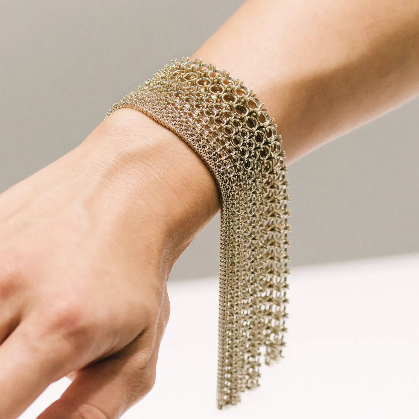Gold chain bracelet worn on wrist featuring layered link from smallest to biggest stone setting design by BÄL Diamonds