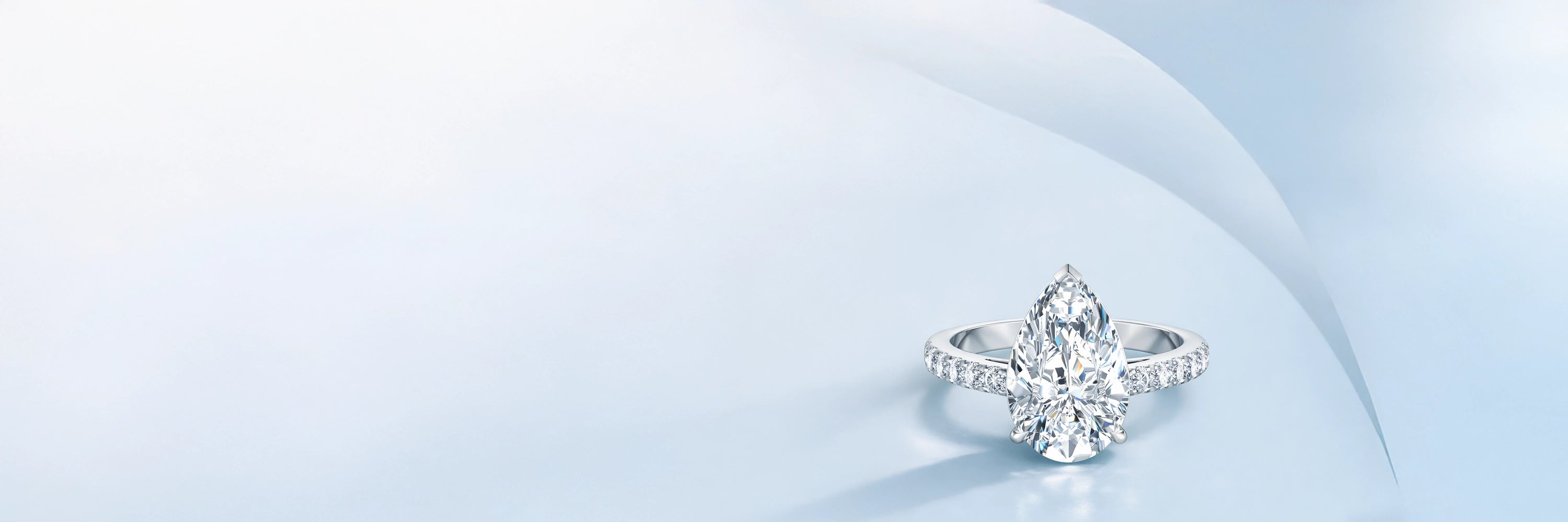 Pear-shaped diamond engagement ring in white gold with pavé band, luxury fine jewelry