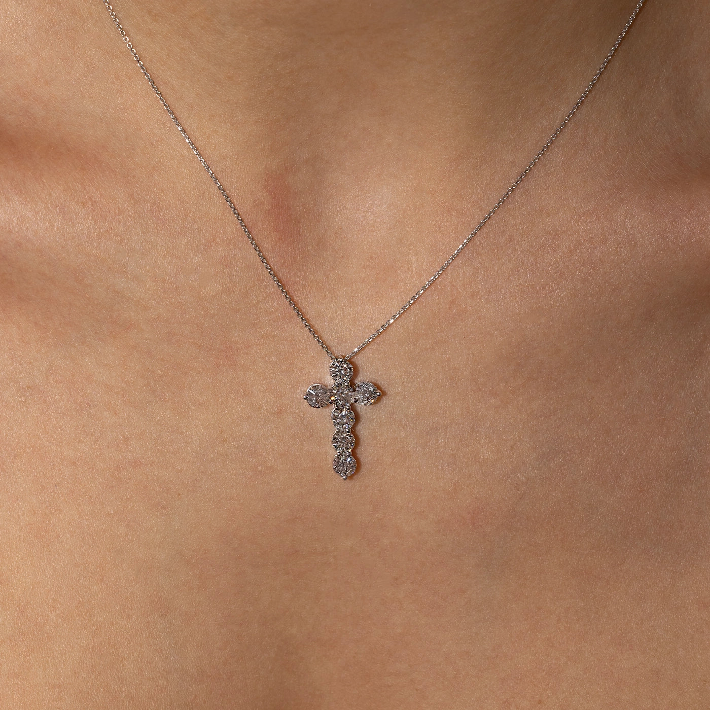 Lab-grown diamond cross pendant necklace in white gold worn on the3 neck of the model