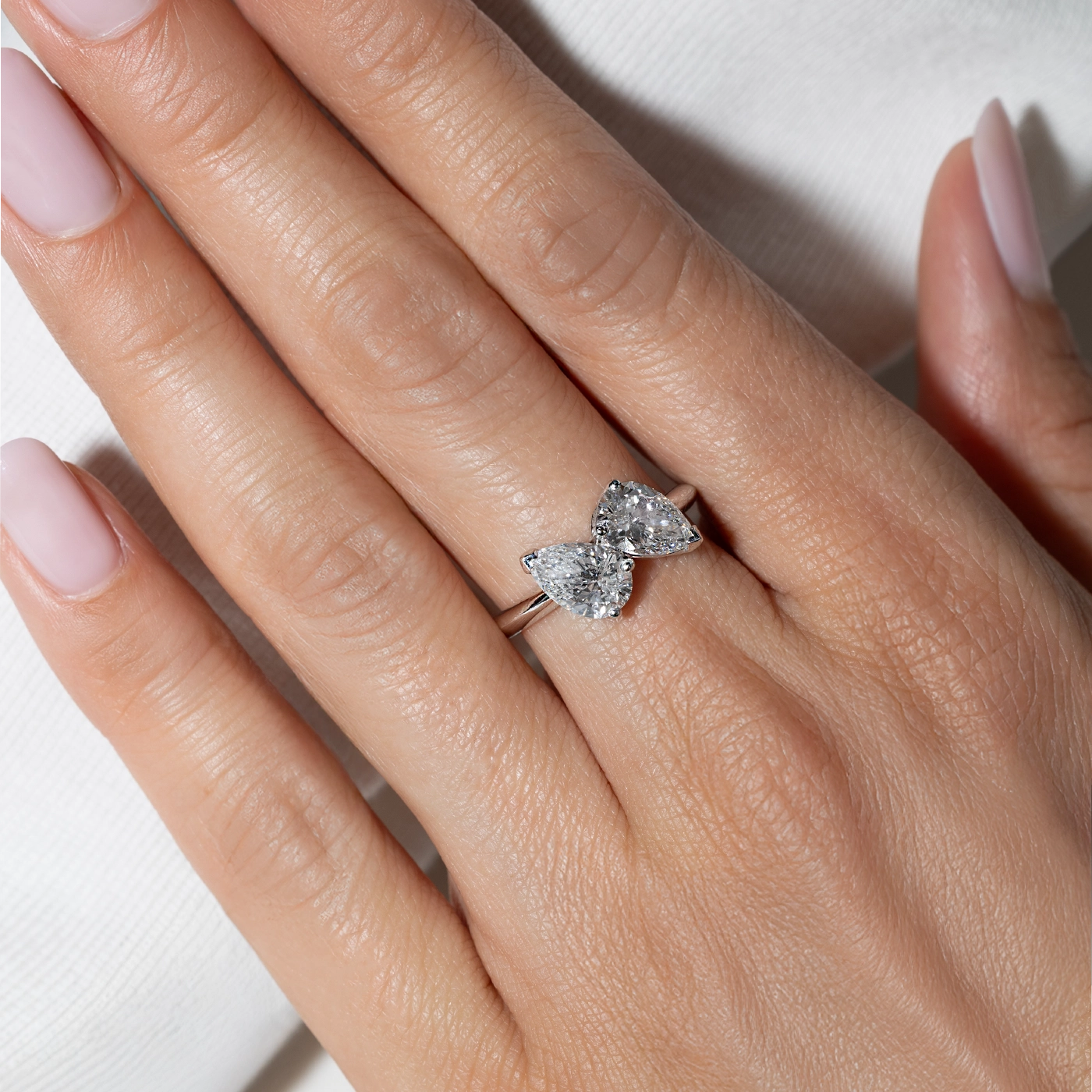 Pear-shaped lab-grown diamond open ring in white gold, worn on the hand.