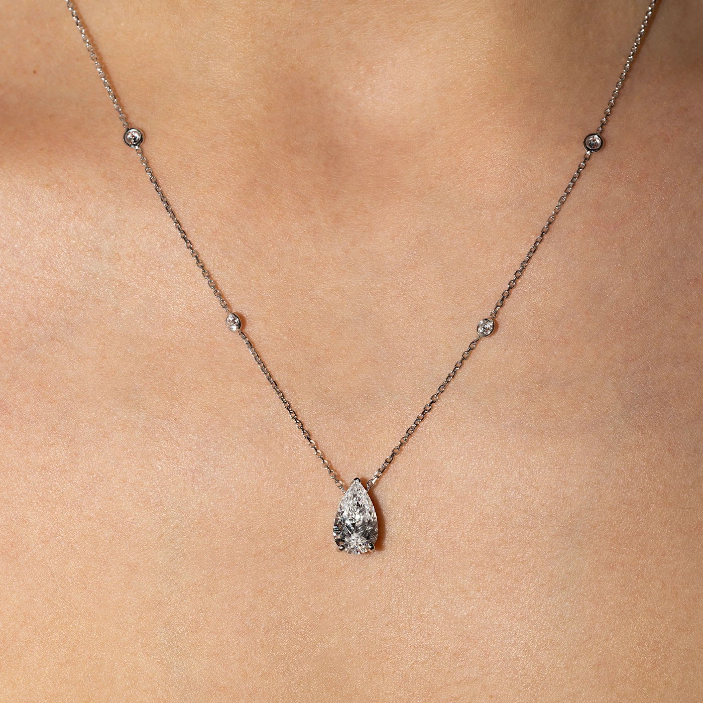 Pear-shaped white lab-grown diamond pendant necklace in white gold with sautoir, worn on the neck.