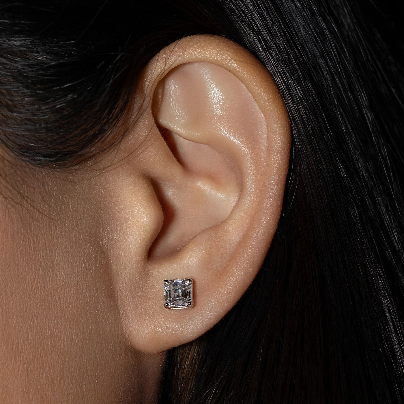 Asscher-cut lab diamonds solitaire earrings worn by the model 