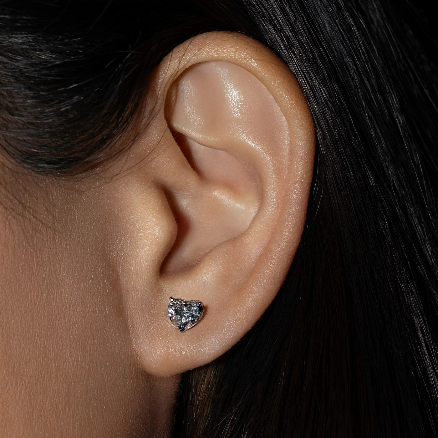 Heart-shaped lab diamonds solitaire earrings worn by the model