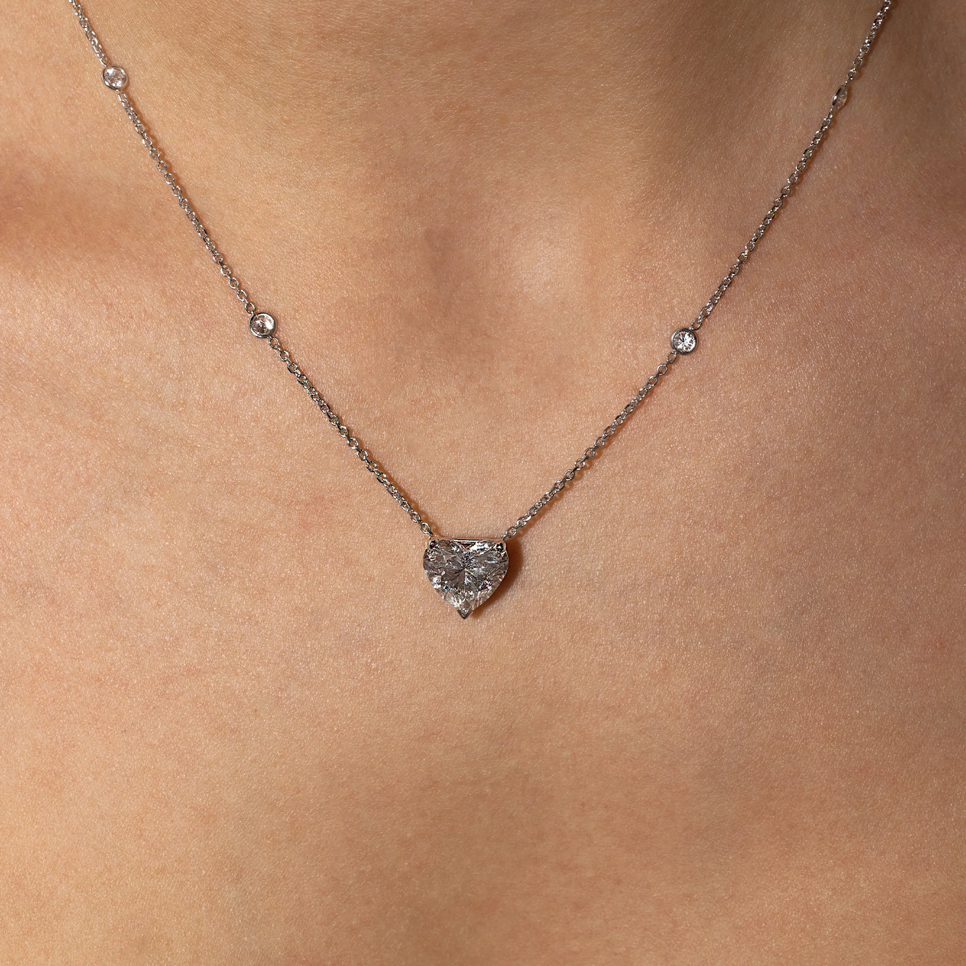 Heart-shaped lab-grown diamond pendant necklace in white gold with sautoir, worn on the neck.
