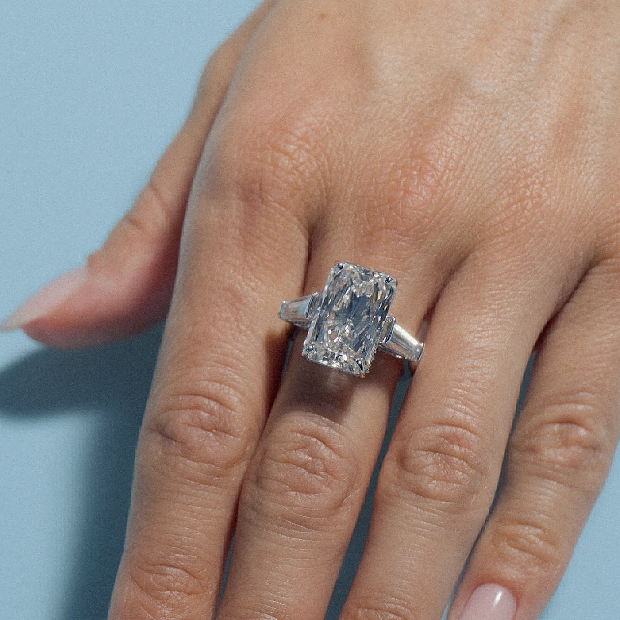 Radiant Lab Diamond Intricate Trilogy ring on a hand with a light blue background