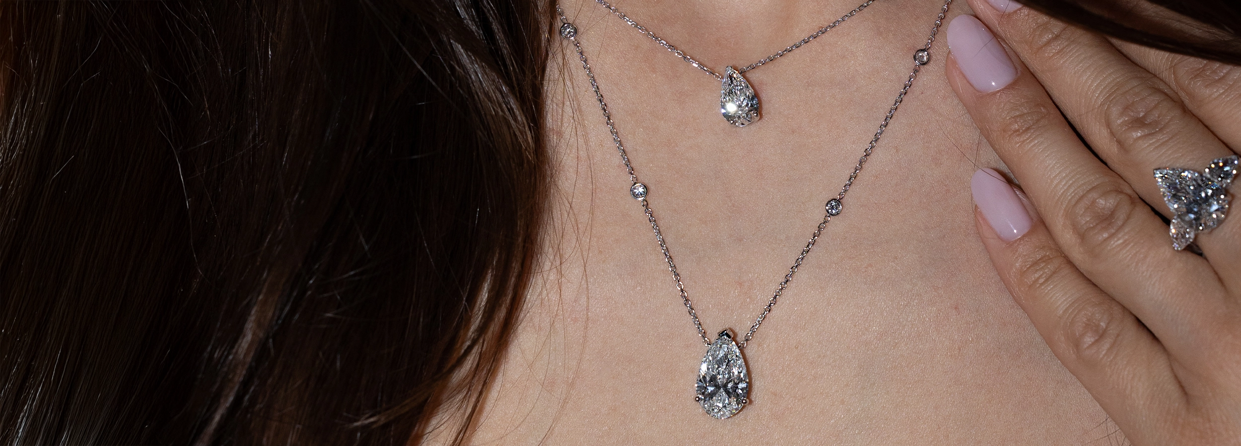 Model wearing a Pear Trilogy White Lab Diamond and two pear-shaped pendants with sautoir