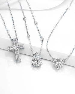 Luxury diamond necklaces in white gold with cross pendant, pear-shaped diamond with Sautoir, and heart-cut diamond charms