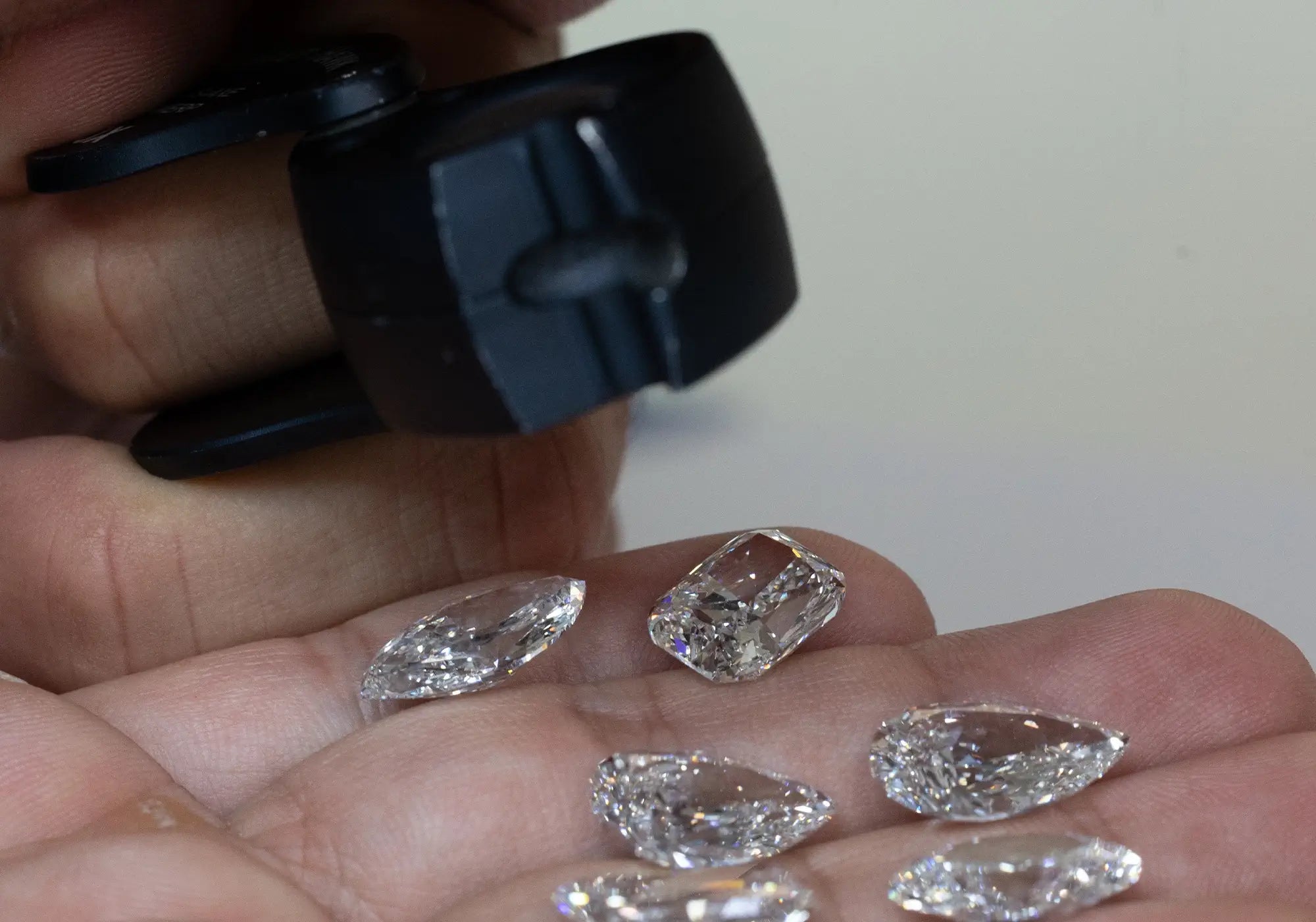 Assorted loose lab diamonds held in a jeweler’s palm while inspecting
