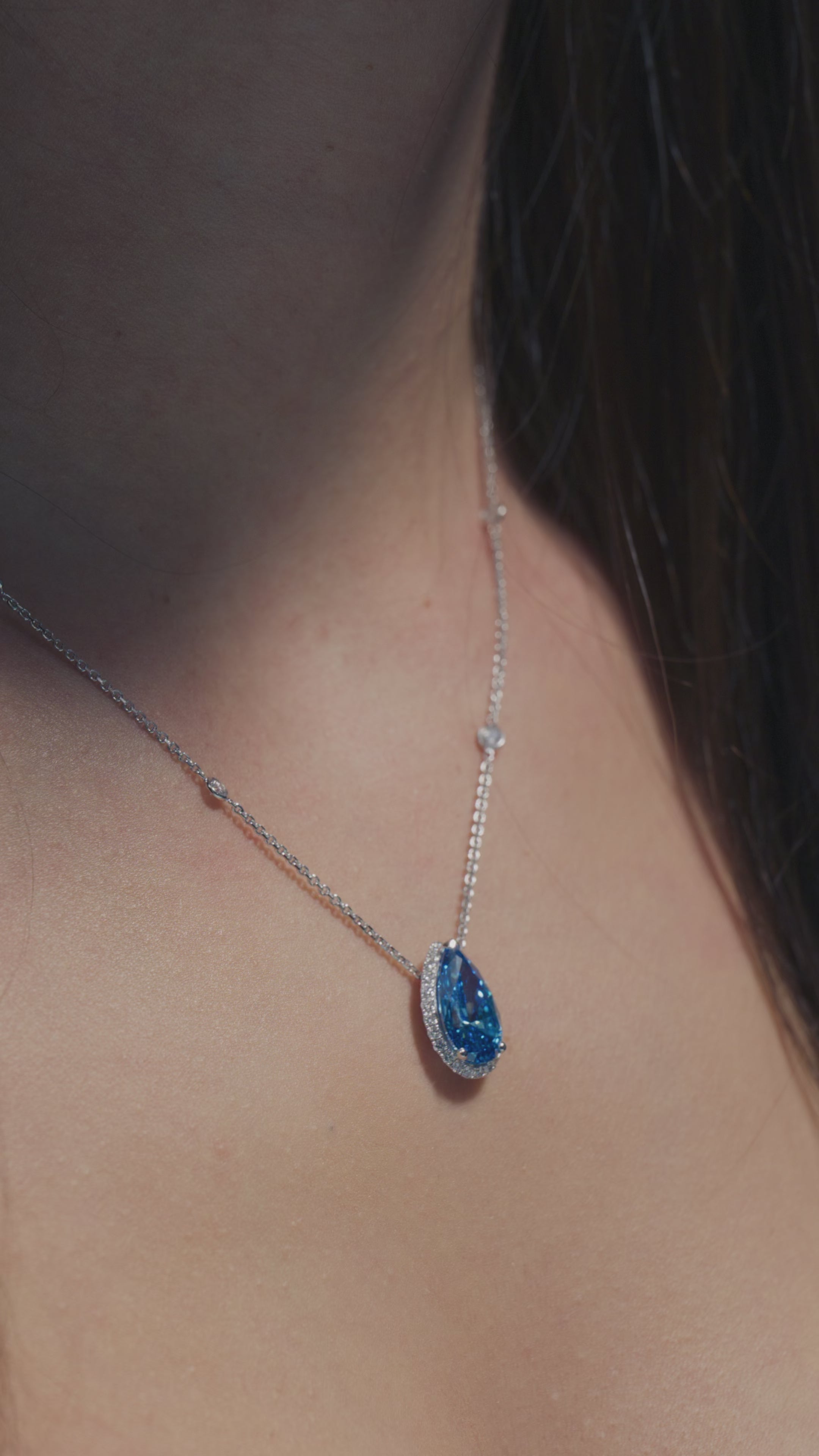 A short clip of a 4.02ct Pear Fancy Vivid Blue Lab Diamond Halo Pendant worn on the neck of the model of BAL Diamonds