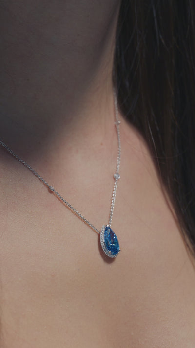 A short clip of a 4.02ct Pear Fancy Vivid Blue Lab Diamond Halo Pendant worn on the neck of the model of BAL Diamonds