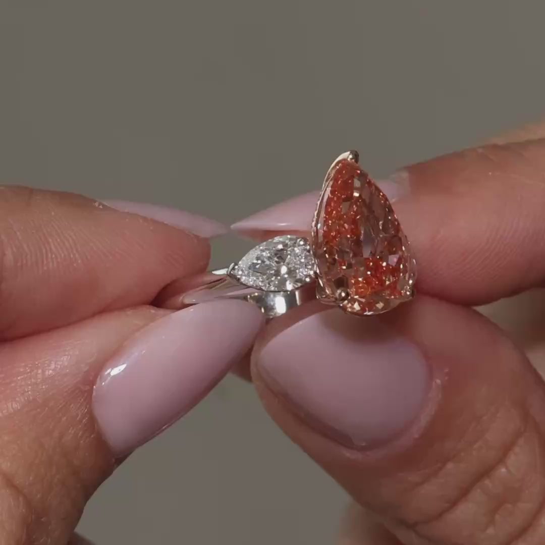 A video presentation of a Pear Fancy Vivid Orangy Pink Lab Diamond Pear Trilogy by the model 