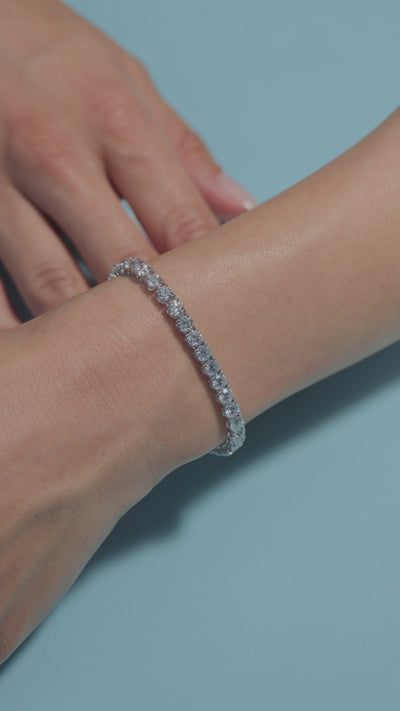 A video presentation of a 10.85ct Round Lab Diamonds Tennis Bracelet shown by the model on her wrist on a light blue  background 