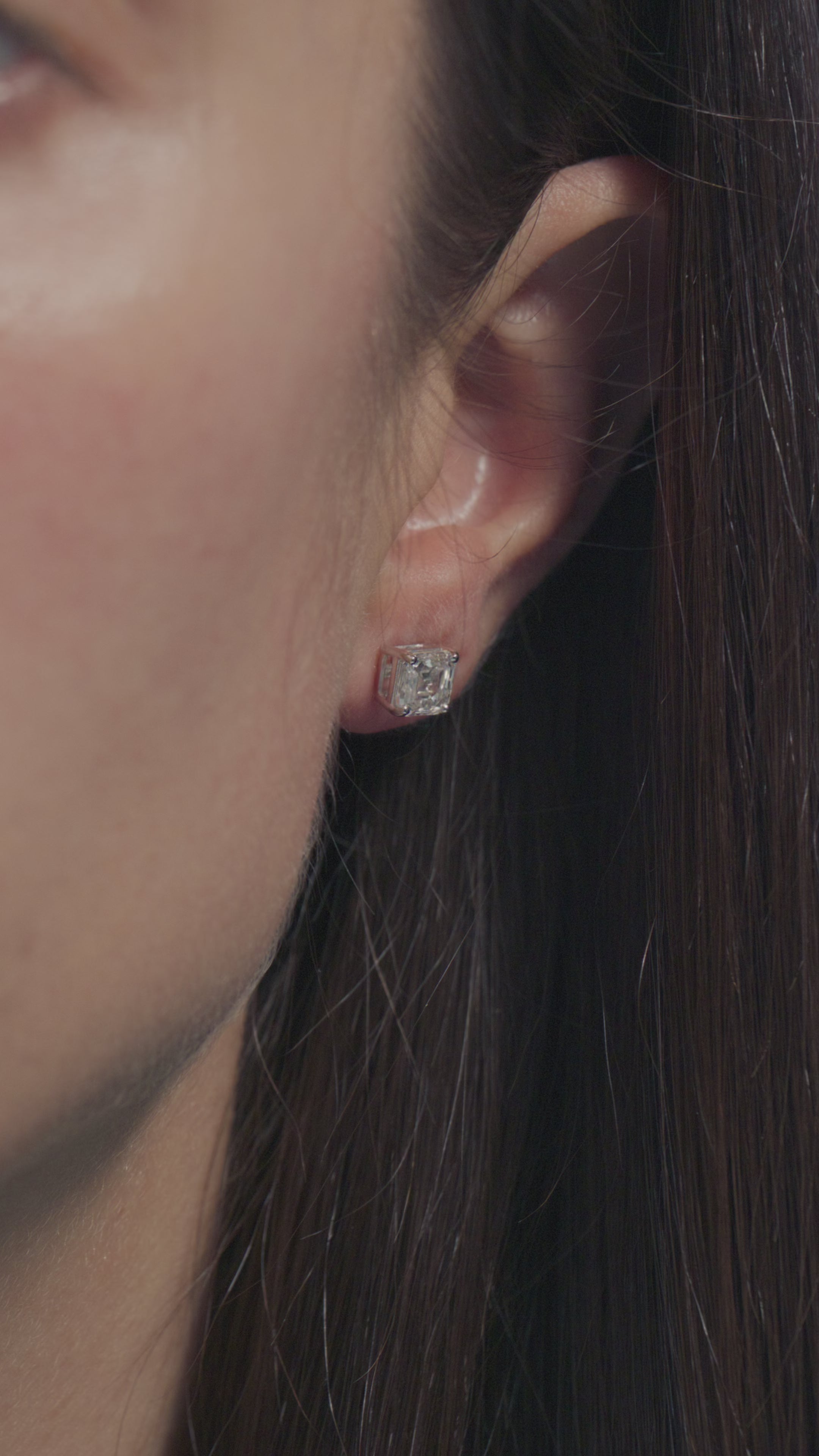 A short video presenting a 1ct Asscher Lab Diamonds Solitaire Earrings worn on the lobe of the model 
