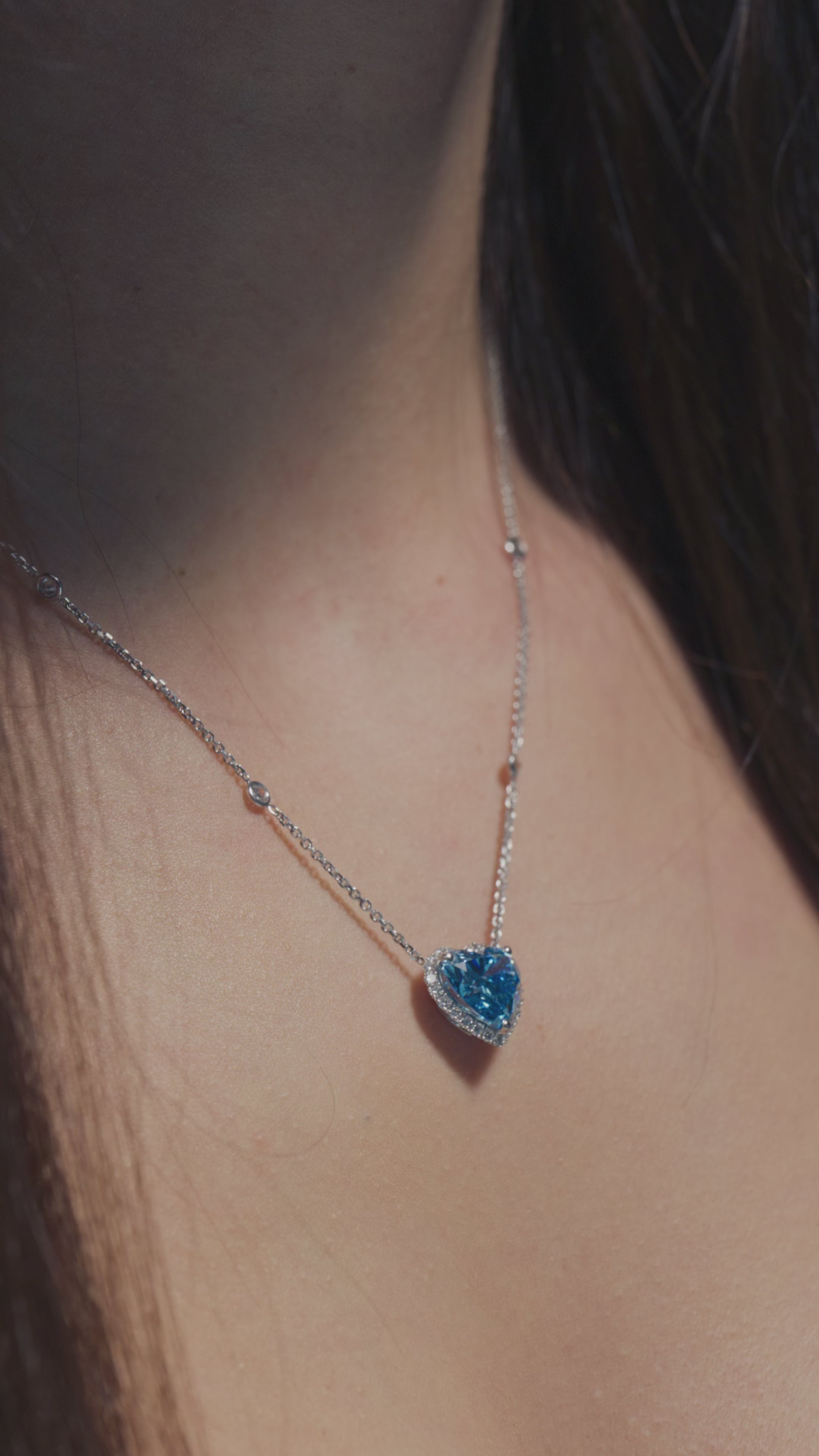 A video featuring a 4ct Heart Fancy Vivid Blue Lab Diamond Halo Pendant worn on the neck of the model 