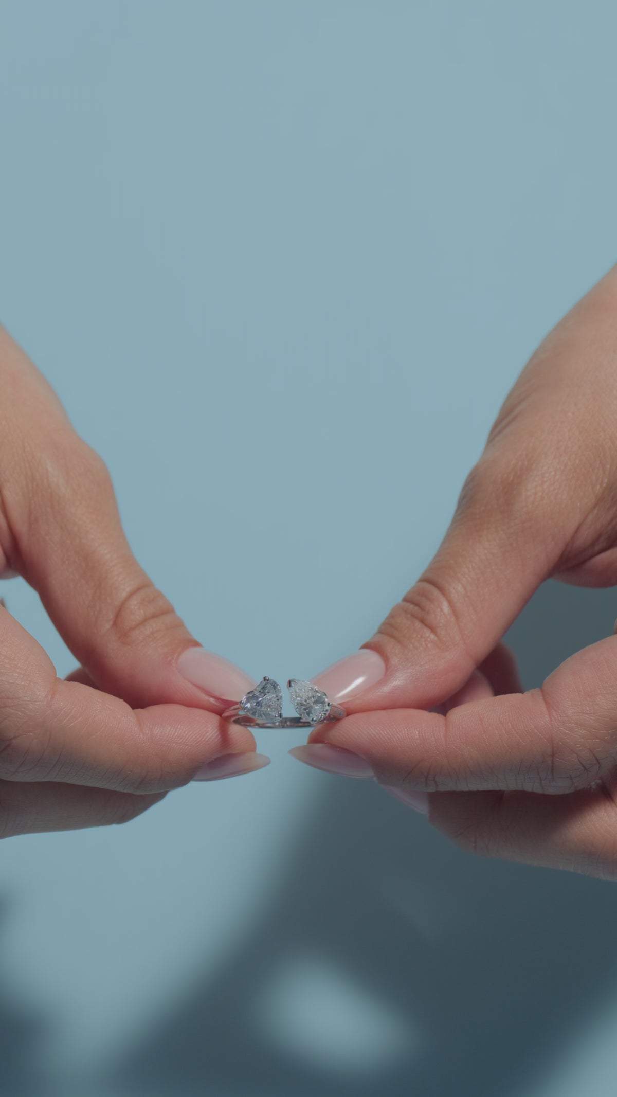 A clip of a 1.99ct Pear-Heart Lab Diamonds Toi & Moi Ring presented by the model of BAL Diamonds on a light blue background