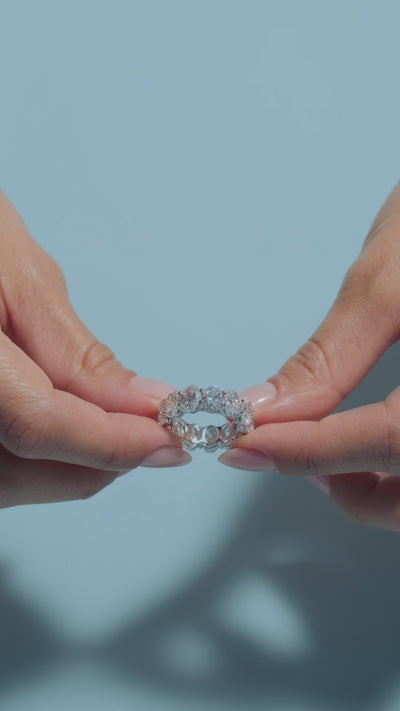 A video clip featuring a 10.59ct Oval Lab Diamonds Eternity Ring held and worn by the model on a light blue backround