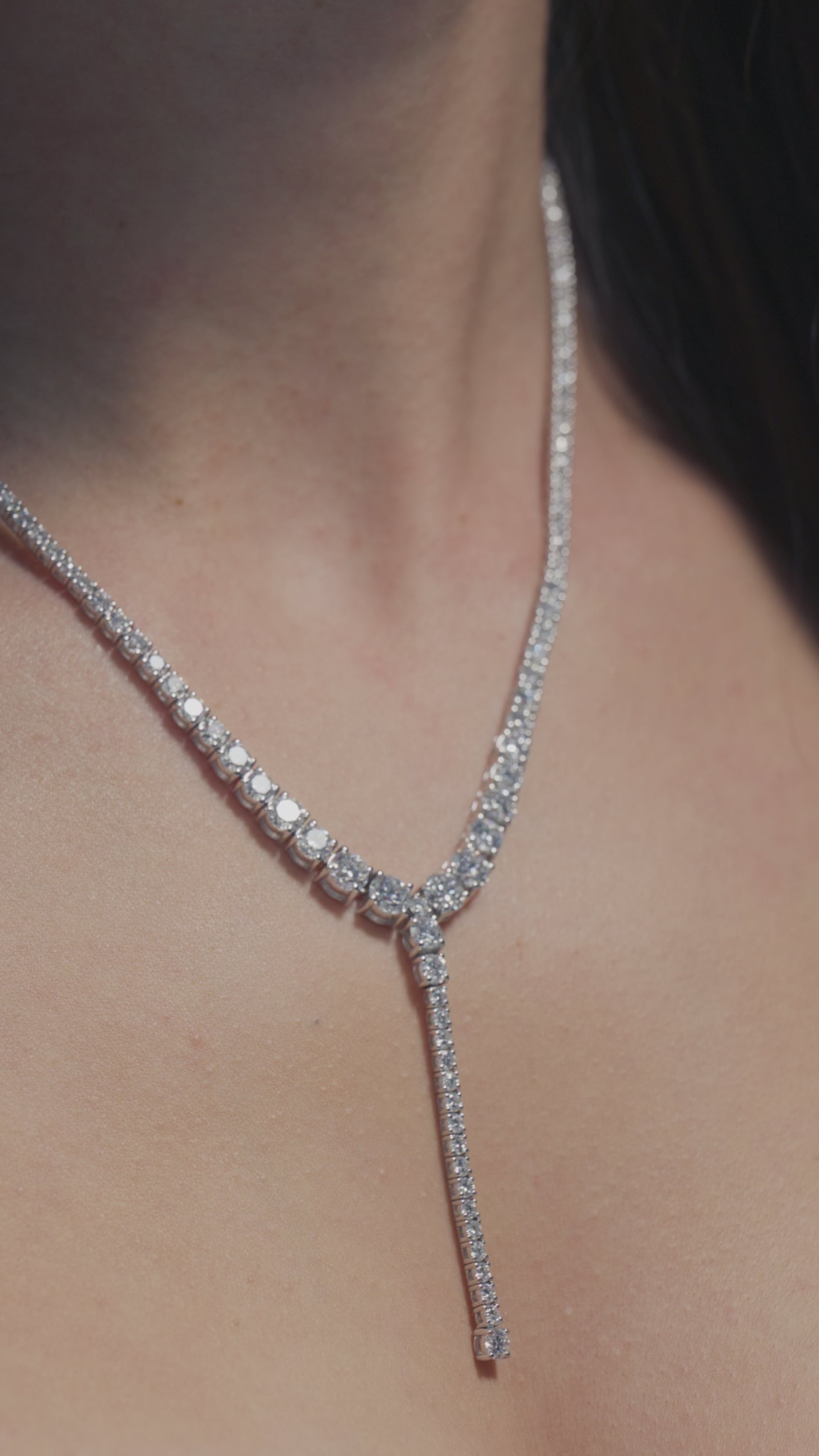 A video presenting a 12.63ct Round Lab Diamond Tapered Drop Tennis Necklace  worn by the model